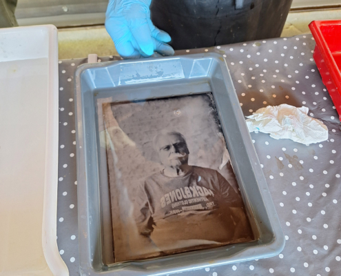 9. Fixierung: Die entwickelte Glas- oder Metallplatte wird mit einer Lösung wie Natriumthiosulfat fixiert, um die nicht exponierten Silbersalze zu entfernen